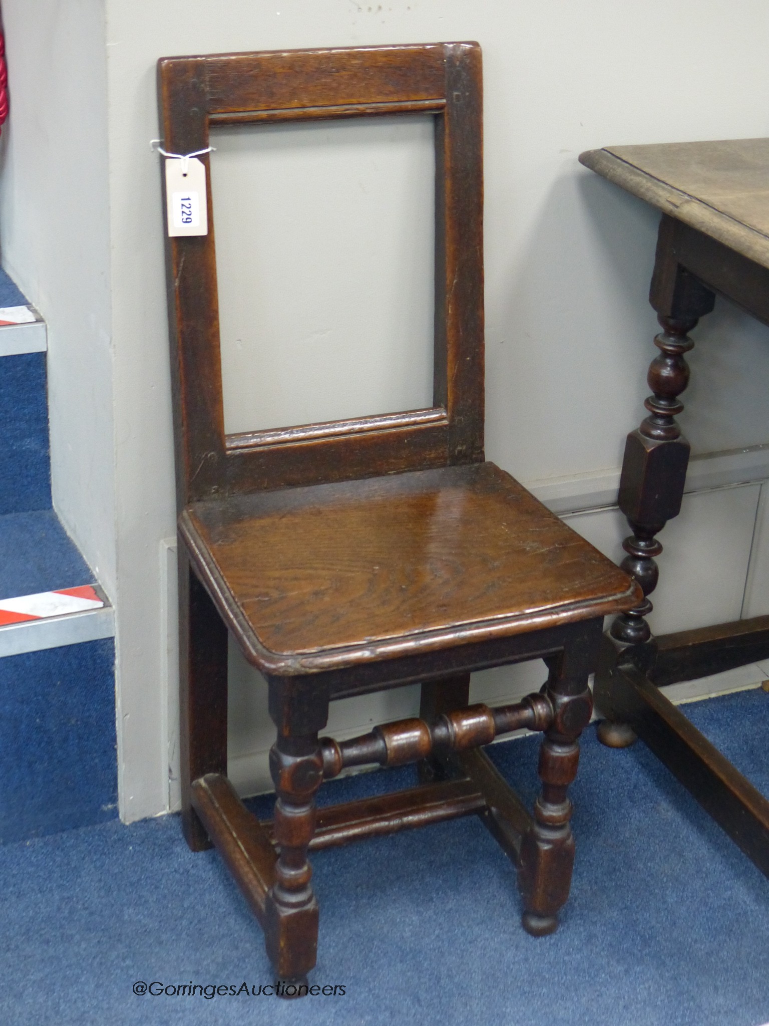 A 17th century Brittany oak back stool, height 84cm